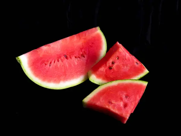 Karpuz, kesme tahtasındaki karpuz dilimleri, siyah arka plan.