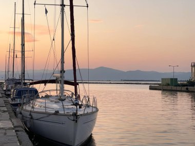  Günbatımında sakin deniz sularında yelkenli.