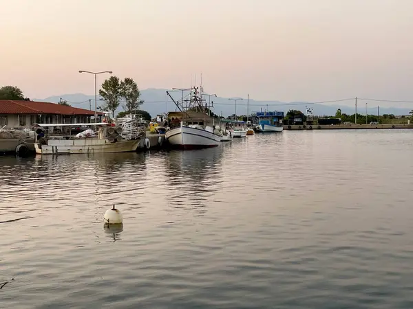 Gün batımında küçük, rahat bir liman. Yatları ve tekneleri sessizce demirlemiş..