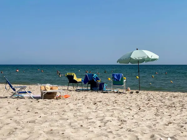 Yaz aile titreşimleri, deniz kenarında güneşli bir günde renkli plaj şemsiyeleri, dinlendirici yaz tatili.