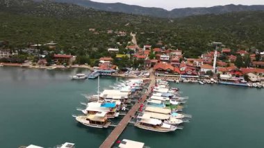 Türkiye 'nin Pier Kemer kentine küçük tekneler yanaştı. İskeleye çok sayıda küçük teknenin yanaştığı huzurlu bir liman sahnesi. Durgun su gökyüzünü yansıtır ve güzel bir kıyı manzarası yaratır. Seyahat, denizcilik ve manzaralı içerik için mükemmel