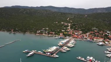 Türkiye 'nin Pier Kemer kentine küçük tekneler yanaştı. İskeleye çok sayıda küçük teknenin yanaştığı huzurlu bir liman sahnesi. Durgun su gökyüzünü yansıtır ve güzel bir kıyı manzarası yaratır. Seyahat, denizcilik ve manzaralı içerik için mükemmel