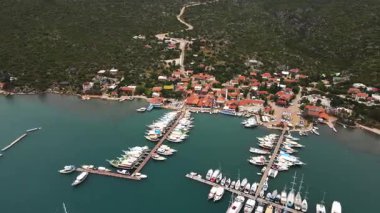 Türkiye 'nin Pier Kemer kentine küçük tekneler yanaştı. İskeleye çok sayıda küçük teknenin yanaştığı huzurlu bir liman sahnesi. Durgun su gökyüzünü yansıtır ve güzel bir kıyı manzarası yaratır. Seyahat, denizcilik ve manzaralı içerik için mükemmel