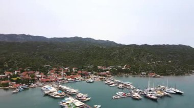 Türkiye 'nin Pier Kemer kentine küçük tekneler yanaştı. İskeleye çok sayıda küçük teknenin yanaştığı huzurlu bir liman sahnesi. Durgun su gökyüzünü yansıtır ve güzel bir kıyı manzarası yaratır. Seyahat, denizcilik ve manzaralı içerik için mükemmel