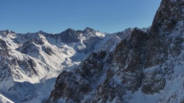 Shymbulak Kayak Merkezi ve Cable Car Snowboardcuları ve Rocky Dağları Almatı, Kazakistan, Turizm, ekstrem sporlar ve Alp keşif temaları. Engebeli tepeler ve karlı yamaçlar Kazakistan 'ın dağlık arazisinin güzelliğini vurguluyor.