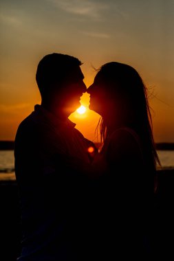 Gün batımında sahilde bir çift.