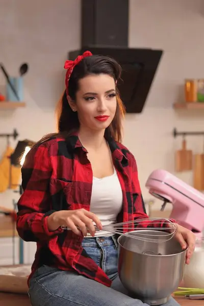 Önlüklü kadın hamur pişiriyor.