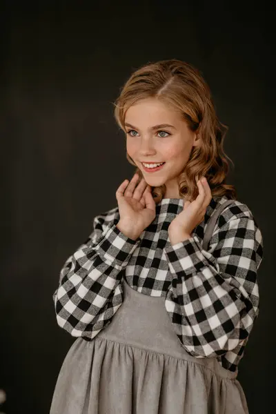 Beyaz kareli elbiseli küçük bir kızın portresi. Stüdyoda manken.