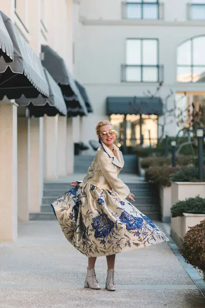 Şık paltolu bir kadın şehirde dolaşıyor.