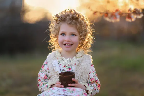 Gün batımında bukleli küçük bir kızın güzel portresi