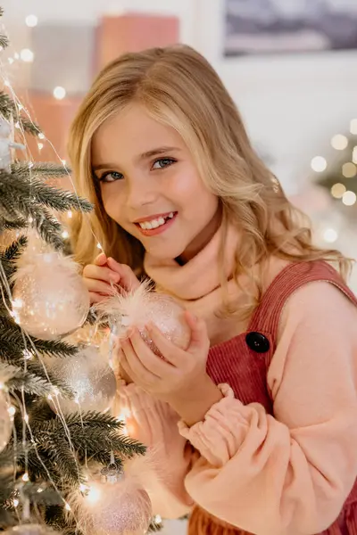 Mutlu küçük kız Noel ağacını süslüyor