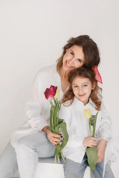 Beyaz tişörtlü, beyaz lale desenli bir anne..