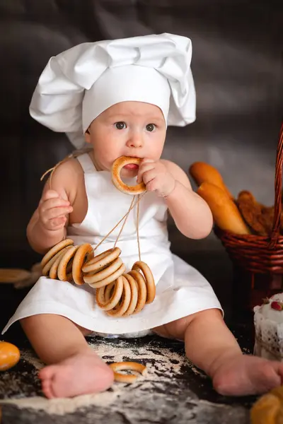 Küçük kız fırında yemek pişirmeye hazırlanıyor. Şapkalı çocuk..