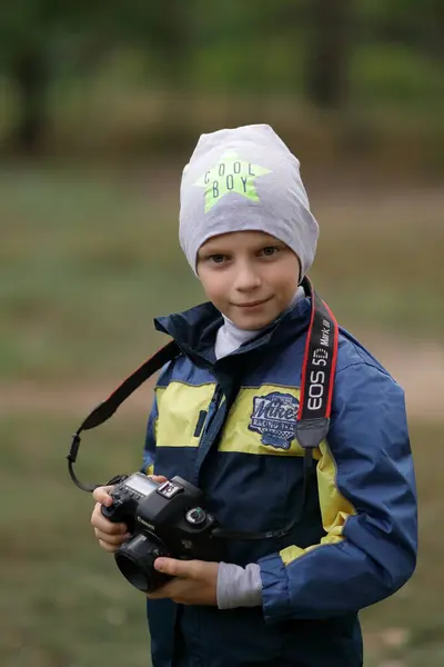 Sonbahar ormanındaki çocuk. Şapkalı ve ceketli bir çocuk. Sonbahar ormanındaki çocuk..
