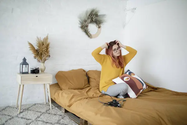 Genç ve güzel bir kadın yatakta kitap okuyor.