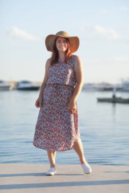 Sahilde şapkalı genç bir kadın.