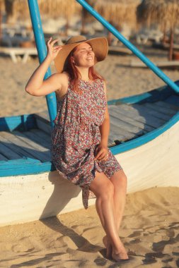 Sahilde şapkalı genç bir kadın.