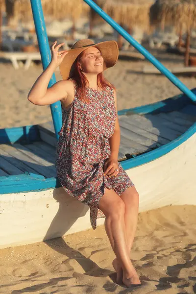 Sahilde şapkalı genç bir kadın.