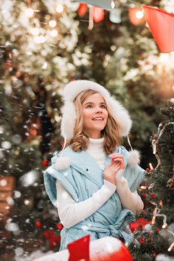 Mavi ceketli, kürklü, buz patenli, buz patenli güzel bir kız.