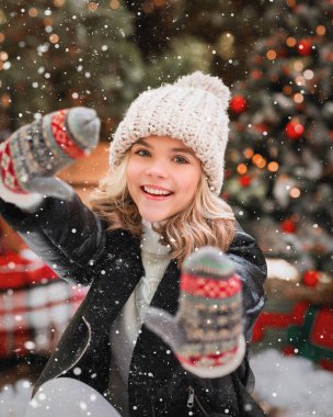 Siyah deri ceketli mutlu bir kız ve buz pateninde bej şapkalı bir kız.