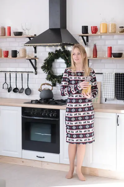 Yeni yıl elbisesi içinde sarışın güzel bir kız. Evde geyik var. Noel ağacının yanında.