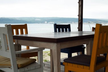 Sahilde arka planda deniz manzaralı bir masa..