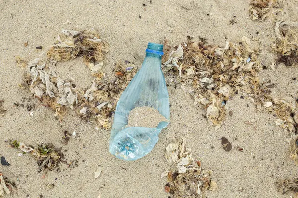 Plajda şişesi olan plastik şişe, çevre kirliliği.