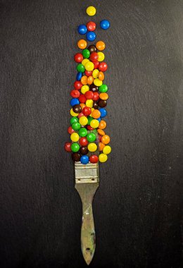 Siyah arkaplanda renkli M & M & M şekerlerinden oluşan tam çerçeve. M & M 'li yaratıcı fotoğraf.