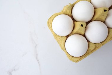 Beyaz arka planda yumurta tepsisine çiğ tavuk yumurtası yakın plan. Karton tepside bir grup taze beyaz yumurta. Organik gıda doğası gereği sağlıklıdır.