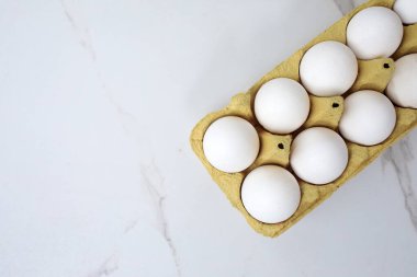 Beyaz arka planda yumurta tepsisine çiğ tavuk yumurtası yakın plan. Karton tepside bir grup taze beyaz yumurta. Organik gıda doğası gereği sağlıklıdır.