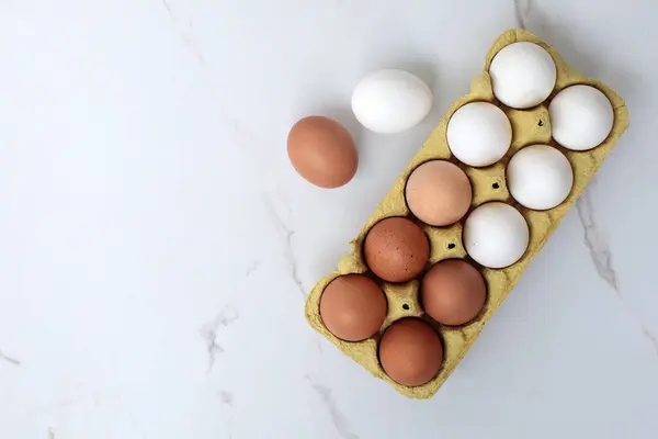 Beyaz arka planda yumurta tepsisine çiğ tavuk yumurtası yakın plan. Karton tepside bir grup taze beyaz yumurta. Organik gıda doğası gereği sağlıklıdır.