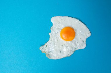 Kavramsal yemek fotoğrafları. Mavi arka planda izole edilmiş bir yumurta..