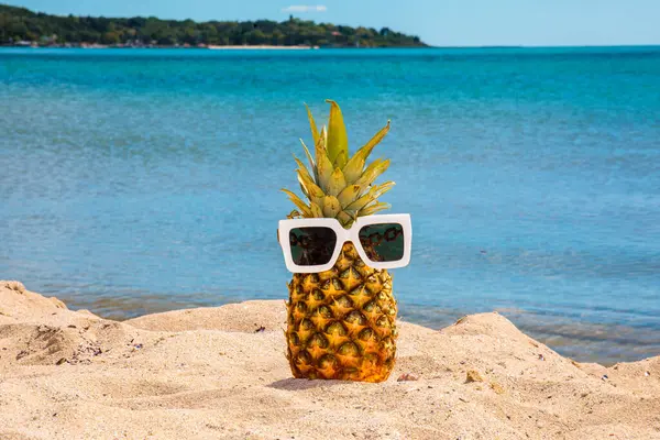 Gözlük takmış ananas. Sahilde bir ananasın güzel bir fotoğrafı. Yazıtlar için sulu yaz arkaplanı