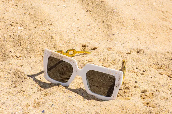Kumsalda kumsalda güneş gözlüğü. İmza ve yazıtlar için yaz sulu arkaplan.