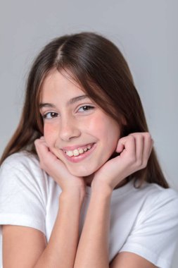 Siyah taytlı, uzun saçlı ve beyaz arka planda fotoğraf stüdyosunun tepesinde güzel bir genç kız. Modellik. Fotoğraf mankeni. Fotoşop. Fotoğraf stüdyosu