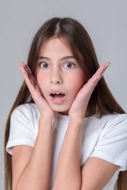 Siyah taytlı, uzun saçlı ve beyaz arka planda fotoğraf stüdyosunun tepesinde güzel bir genç kız. Modellik. Fotoğraf mankeni. Fotoşop. Fotoğraf stüdyosu