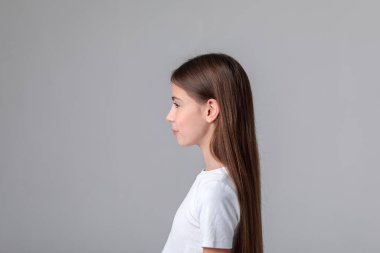 Siyah taytlı, uzun saçlı ve beyaz arka planda fotoğraf stüdyosunun tepesinde güzel bir genç kız. Modellik. Fotoğraf mankeni. Fotoşop. Fotoğraf stüdyosu