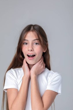 Siyah taytlı uzun saçlı güzel bir genç kızın portresi ve beyaz arka planda bir fotoğraf stüdyosunun kapağı. Farklı duygular. Duygusal bir çekim. Modellik. Fotoğraf mankeni. Fotoğraf oturumu.