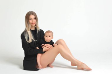 Anne ve küçük oğlu beyaz arka planda fotoğraf stüdyosunda. Anneler Günü..
