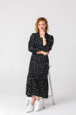 Retro elbise giymiş güzel bir genç kadının tam boy portresi. Gri stüdyo arka planında izole.