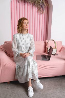 Pembe bluzlu ve beyaz elbiseli güzel bir kızın portresi.