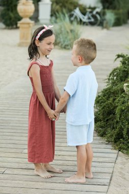 Denizin arka planında birbirine aşık iki küçük çocuğun portresi. Mutlu aile