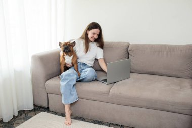 Evdeki bilgisayarını kullanan genç bir kadın..