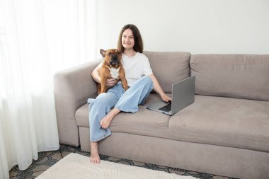 Kanepede köpeği olan evcil bir kadın.