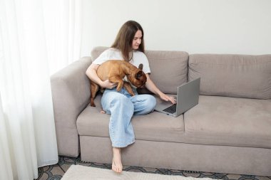Evdeki kanepede köpeği olan bir kadın. Bir kadın köpek kullanır..