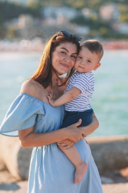 Mutlu anne ve küçük oğlu yazın sahilde.
