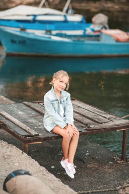 Şirin kız eski ahşap iskelede oturuyor..