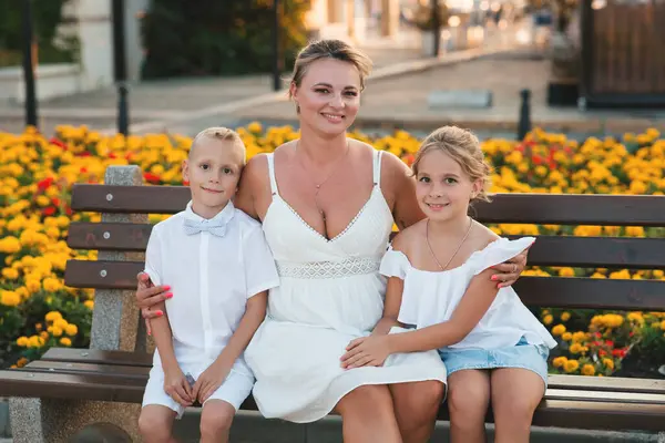 Sıcak bir akşamda, yaz parkında arka planda anne ve oğlunun portresi.