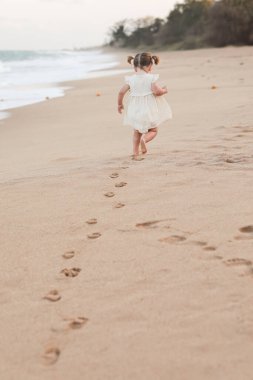 Sahilde beyaz elbiseli genç bir kız.