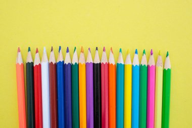Sarı arka planda renkli kalemler. Yazıtlar için parlak, sulu bir arka plan. Yaz dönemi. - Okul. 1 Eylül. Ofis. Çalış.